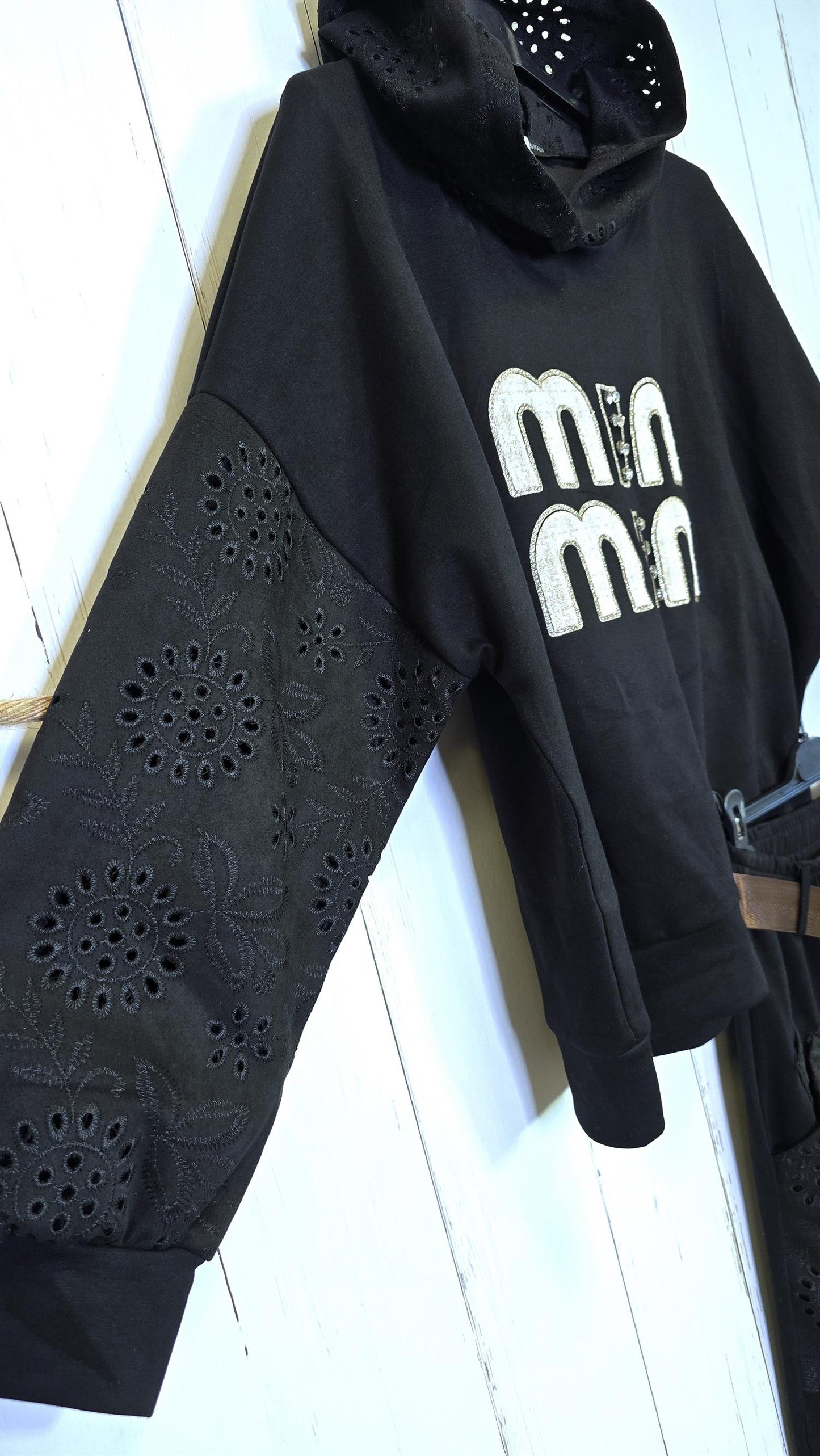 Sort genser med broderte detaljer