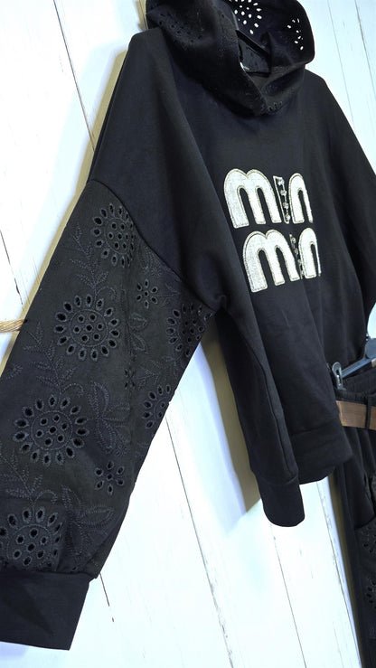 Sort genser med broderte detaljer