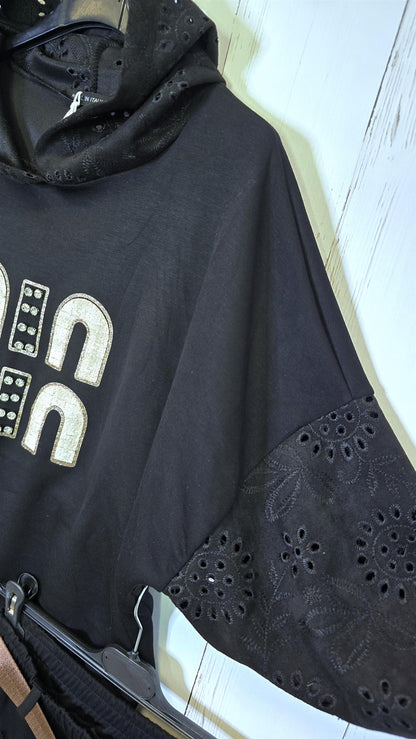 Sort genser med broderte detaljer