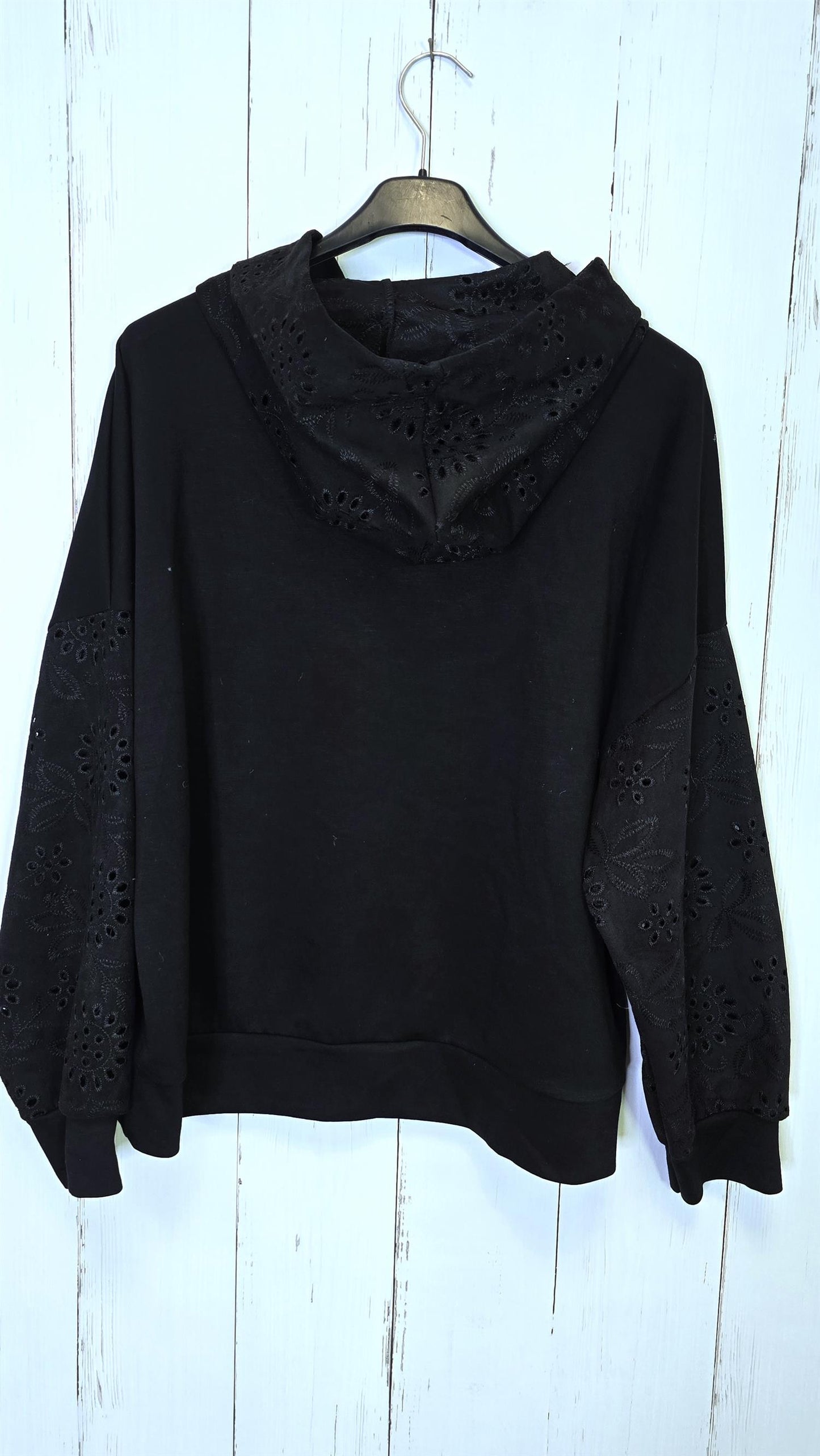 Sort genser med broderte detaljer